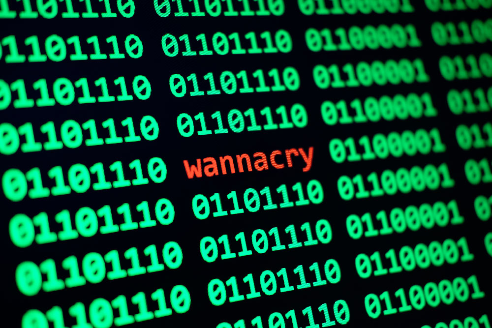 The text WannaCry in red surrounded by green binary numbers